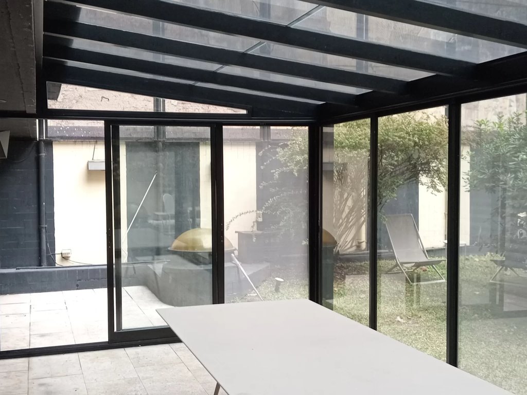 Cerramiento para patio con perfiles de aluminio y vidrio de Plus Metal