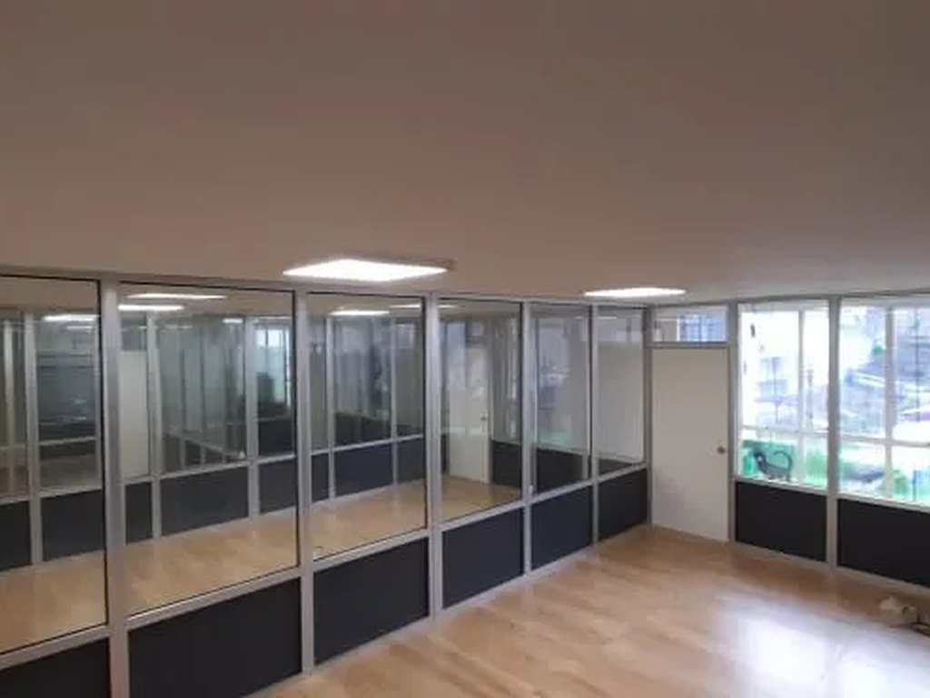 Tabiquería de oficina en aluminio y vidrio instalada por Plus Metal en Zona Norte